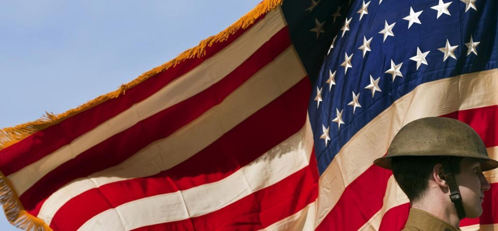 A modern portrait in WWI-era uniform framed by an American flag — symbolizing remembrance of those who served in World War I, the origin of Armistice Day.